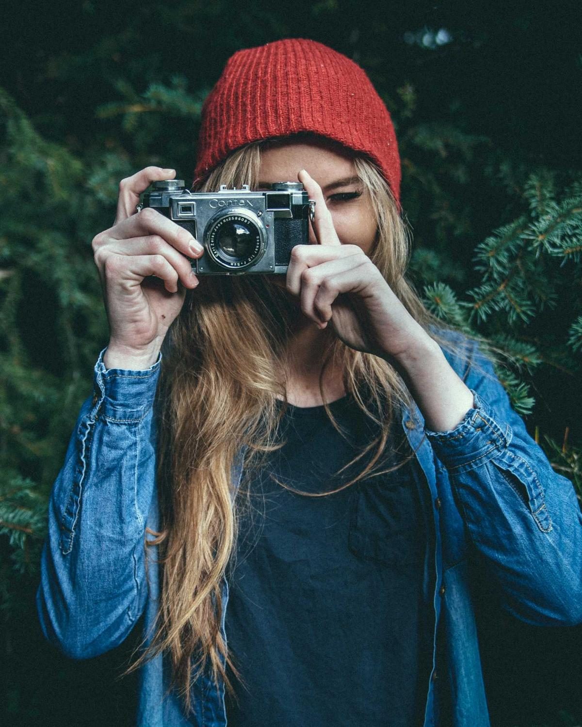 Vrouw met rode muts maakt een foto